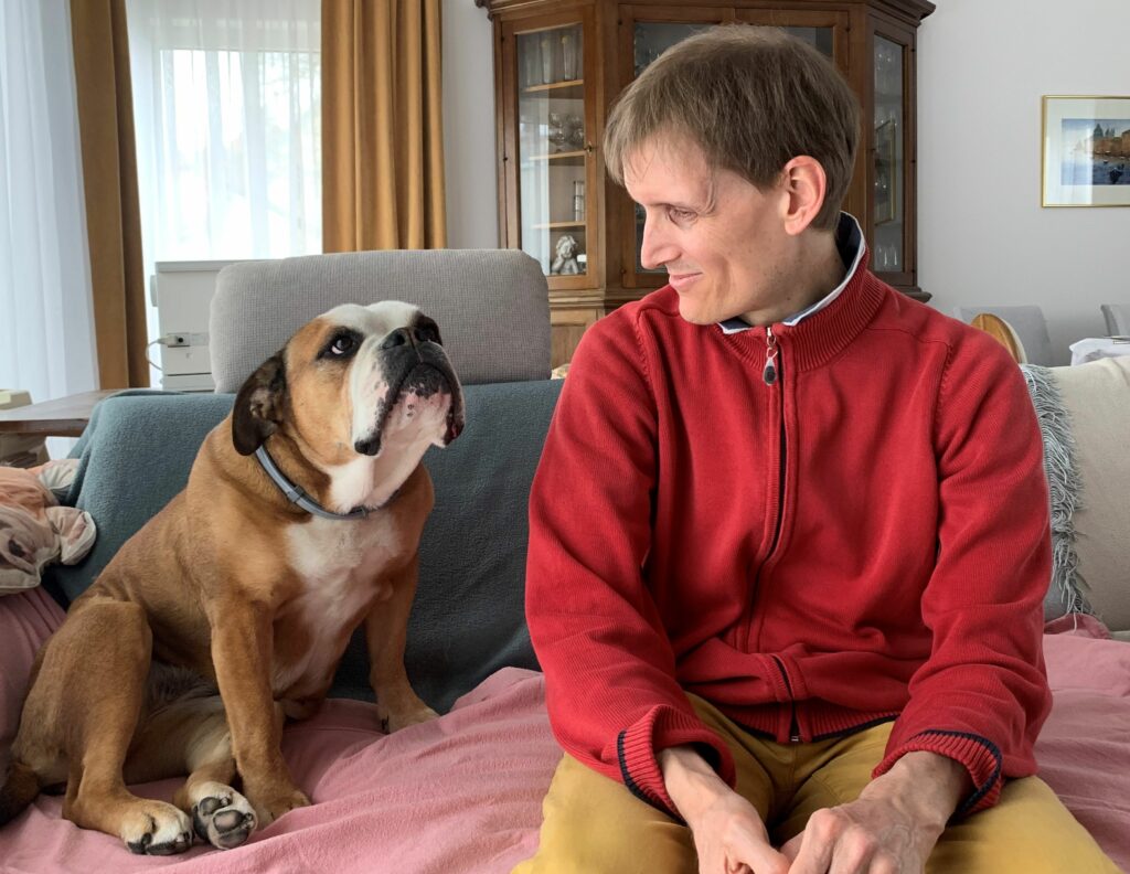 Clemens Pistauer und eine Bulldogge, die er energetisch behandelt hat schauen einander an.