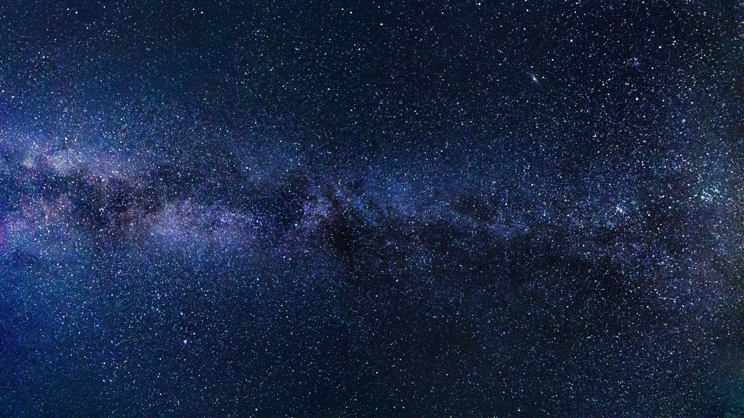 Indigoblauer Sternenhimmel. Horizontal über das Bild erstreckt sich ein Spiralarm unserer Milchstrasse.