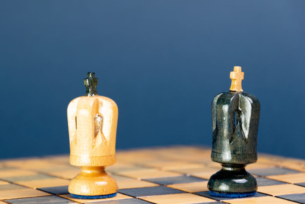 Ein schwarzer und ein weißer König stehen einander auf einem Schachbrett in Patt-Stellung gegenüber.