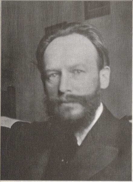 Christian Morgenstern schaut mit ernstem Blick in die Kamera. Sein Haar ist dunkel und er trägt einen Vollbart und seine Kleidung besteht auf einem weißem Hemd, dunklem Sakko und dunkler Krawatte.
